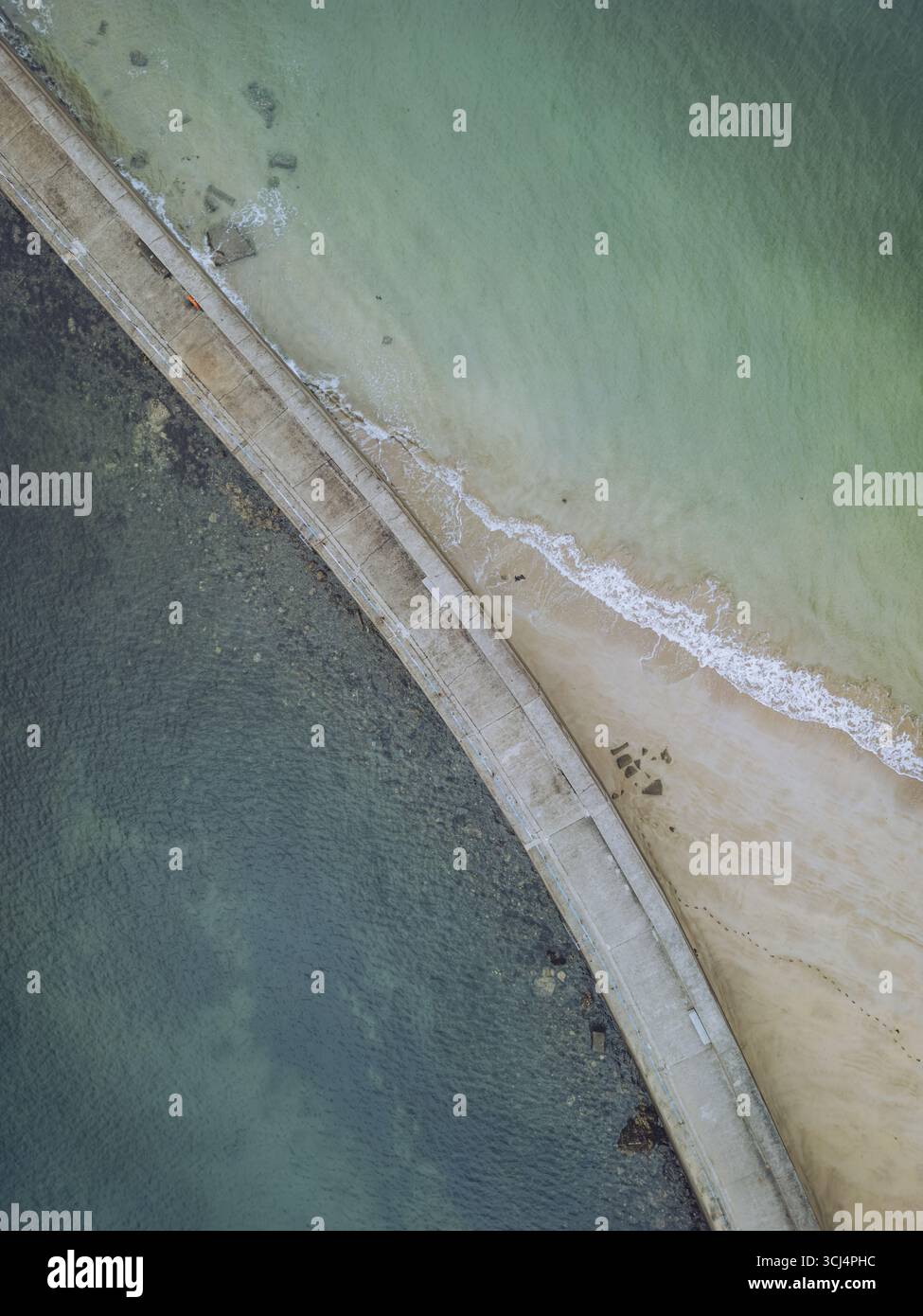 Aus der Vogelperspektive auf das türkisfarbene und dunkelblaue Wasser, geteilt durch einen schmalen Landstreifen mit Sandstrand, Saint-Malo, Bretagne, Frankreich. Stockfoto