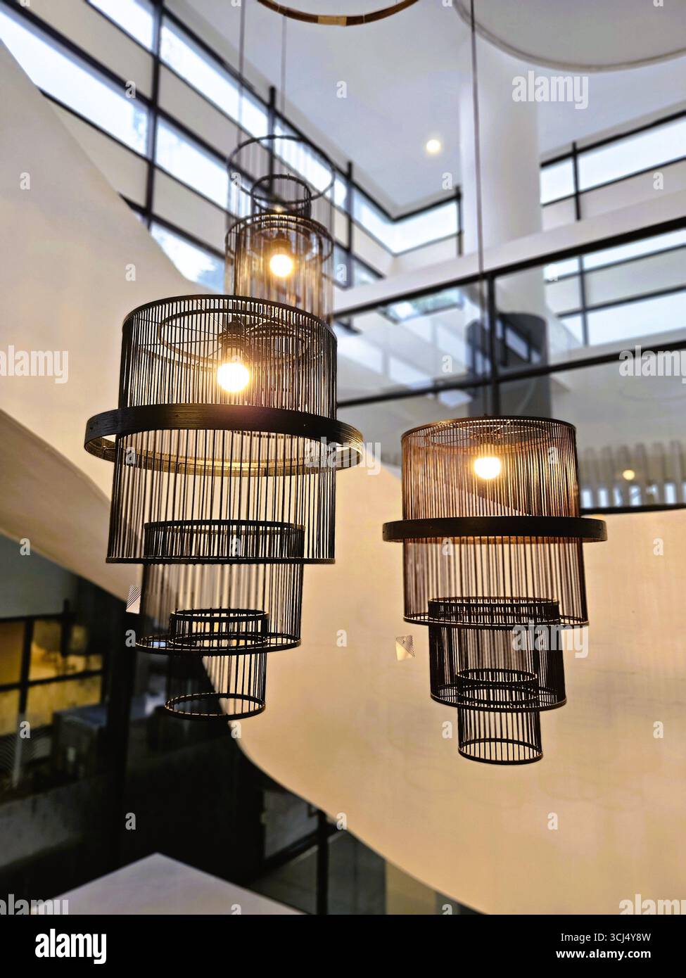 Dekorative Hängelampen mit gewebten Schwarztönen in moderner Inneneinrichtung - Smartphone-aufgenommenes Stockfoto