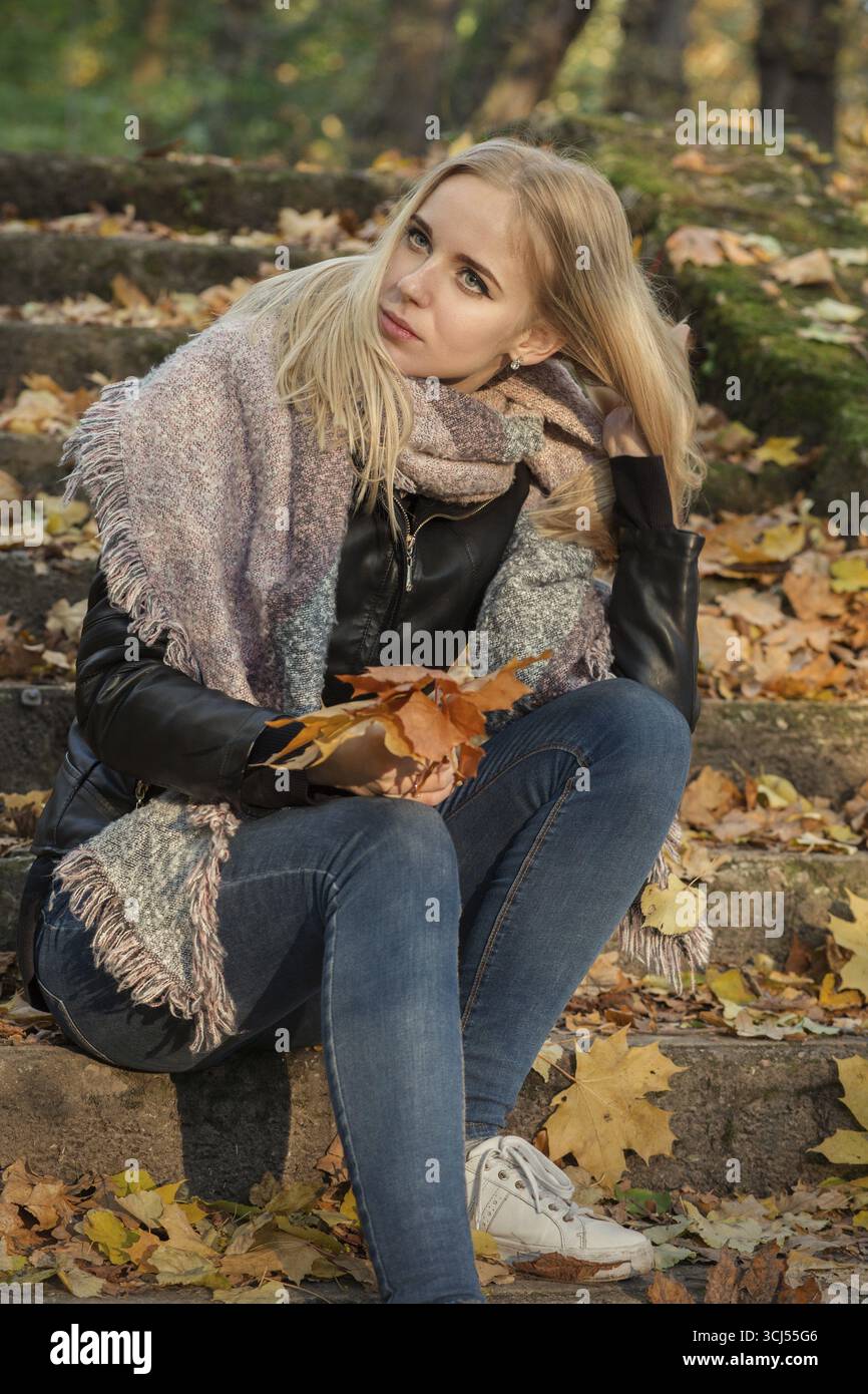 Trauriges Mädchen im Herbstpark sitzend, gedämpftes Bild Stockfoto Trauriges Mädchen im Herbstpark sitzend, gedämpftes Bild Stockfoto