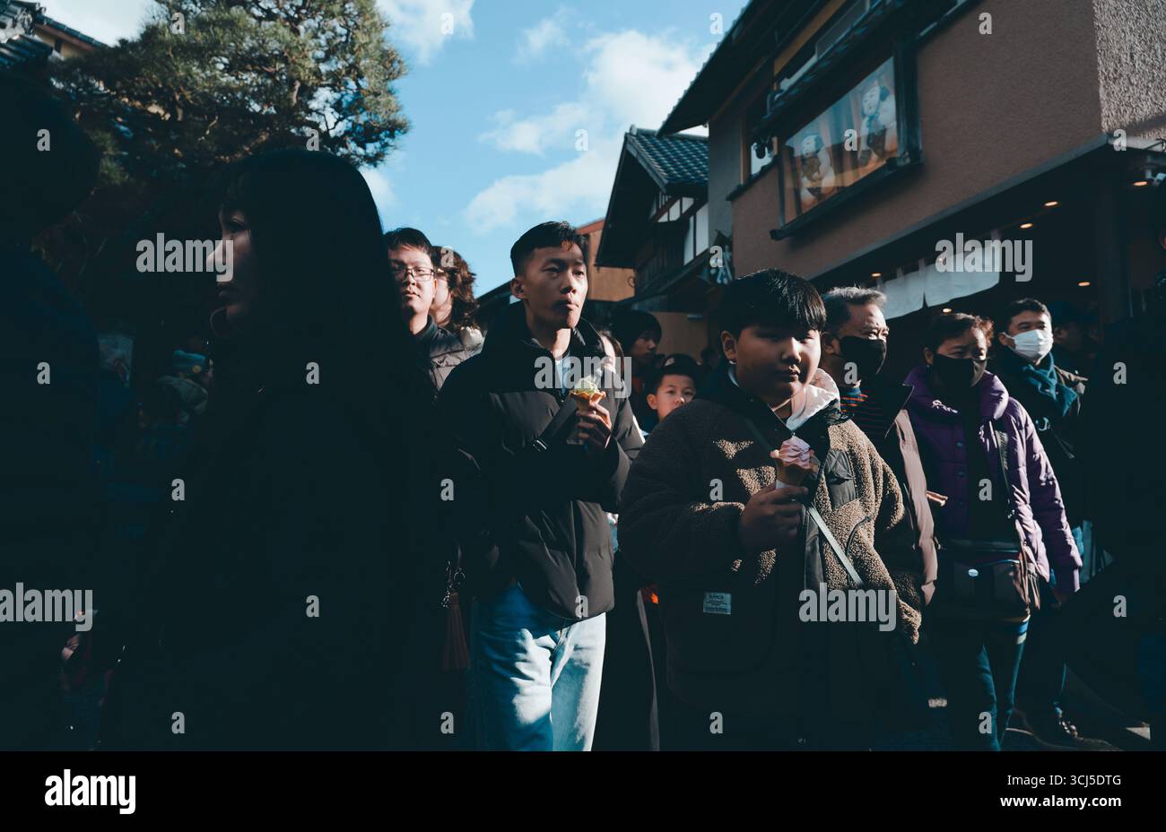 Starkes Winterlicht durchquert eine überfüllte Straße im Stadtteil Higashiyama von Kyoto Stockfoto