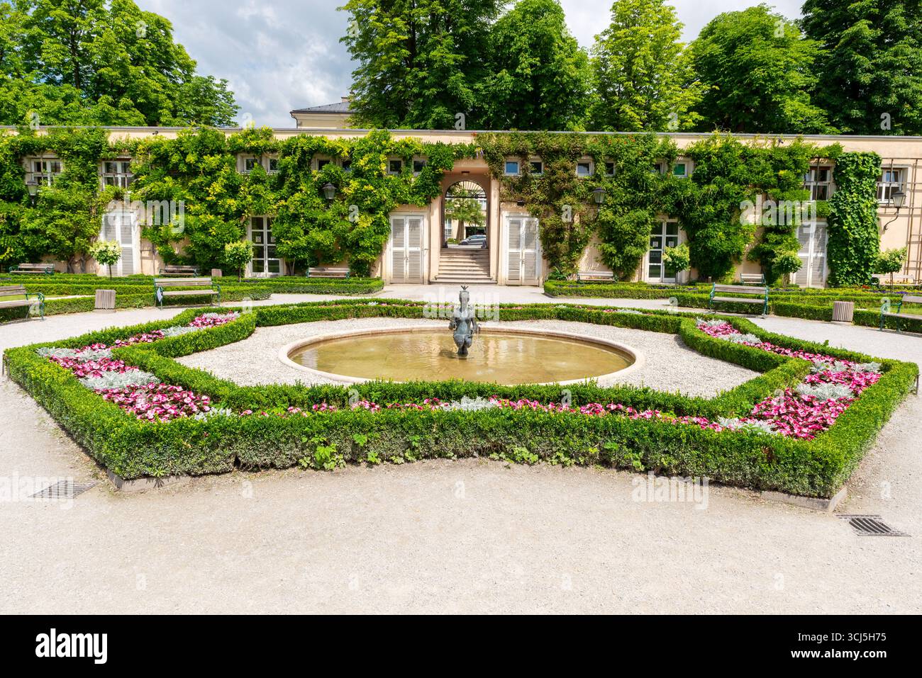 Wunderschöner Garten mit Brunnen, Blumen und grünen Hecken im Mirabell Palace Gardens Stockfoto