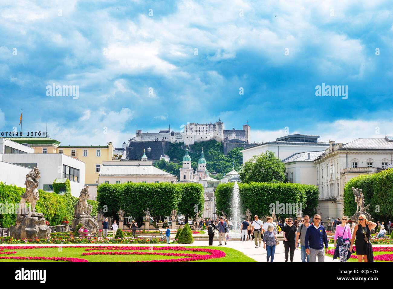 Salzburg, Österreich – 23. Juni 2024: Mirabellgärten mit Blumenbeeten, Springbrunnen und Festung Hohensalzburg im Hintergrund sichtbar Stockfoto