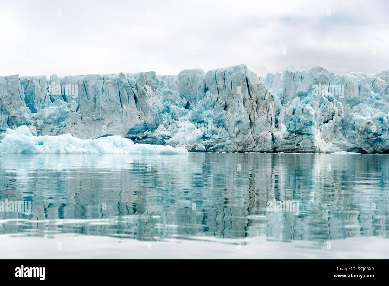 Lilliehöökfjorden Gletscher Spitzbergen Svalbard Norwegen // SPITZBERGEN, Svalbard — das Gesicht des Lilliehöökfjorden Gletschers in Spitzbergen, Svalbard, Norwegen, zeigt dramatische Eisformationen und Gletscherspalten. Dieser Gletscher ist Teil der riesigen Eiskappe, die den Archipel bedeckt. Gletscher in Svalbard sind wichtige Indikatoren des Klimawandels und ein wesentliches Merkmal der arktischen Landschaft. Die Region ist bekannt für ihre einzigartige Artenvielfalt und ihre raue, schöne Umgebung. Spitzbergen ist die größte Insel im Svalbard-Archipel im Arktischen Ozean. Stockfoto