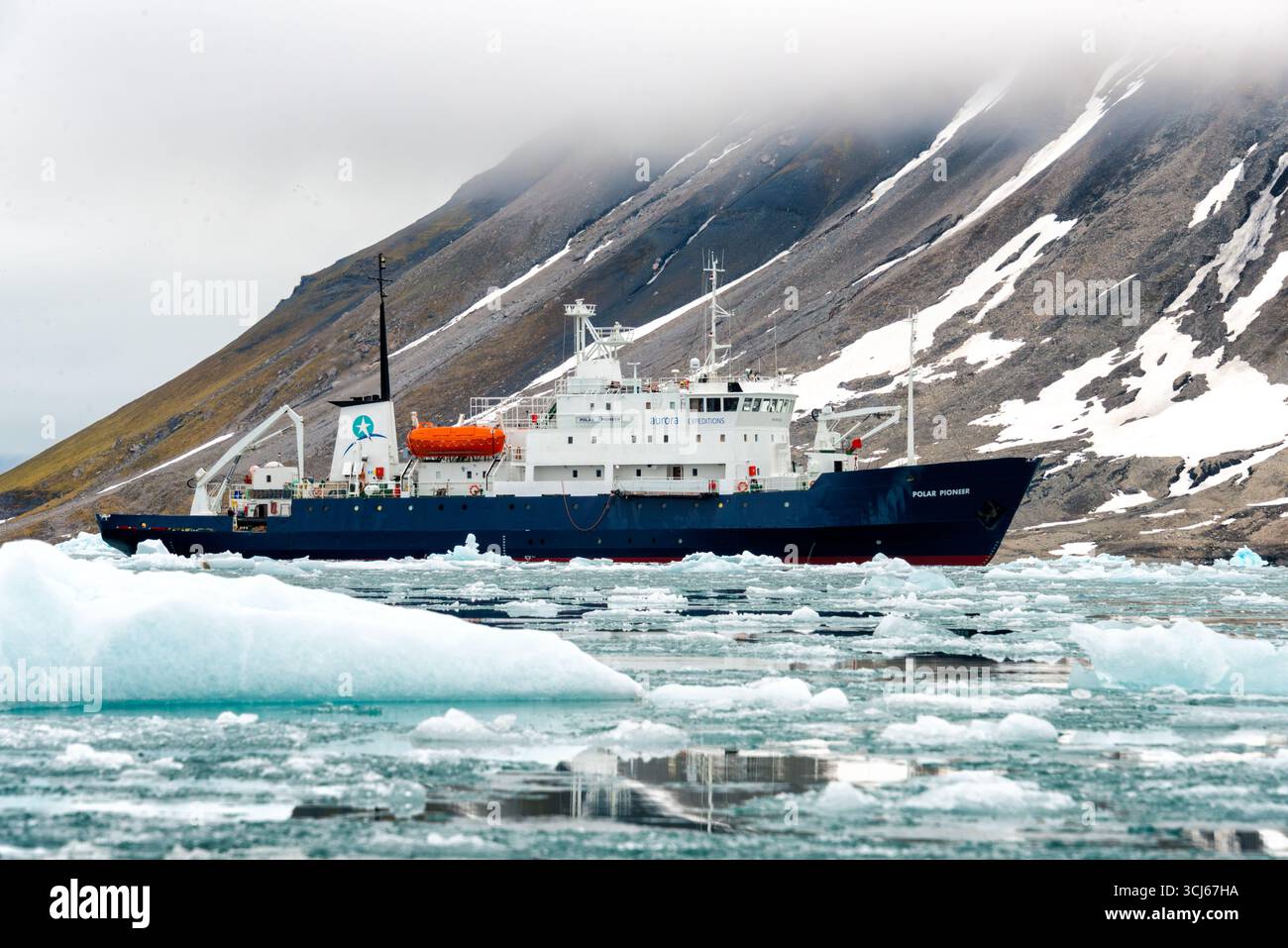 Polar Pioneer Ship in Hornsund Svalbard Norwegen // HORN SUND, SVALBARD UND JAN MAYEN — das Expeditionsschiff Polar Pioneer navigiert durch eine vereiste Bucht in Hornsund. Das Schiff, das von Aurora Expeditions betrieben wird, ist für Polarreisen und Erkundungen ausgelegt. Hornsund ist eine Siedlung und Fjord an der Südspitze der Insel Spitzbergen im Svalbard-Archipel. Der Svalbard-Archipel liegt im Arktischen Ozean, auf halbem Weg zwischen dem norwegischen Festland und dem Nordpol. Stockfoto