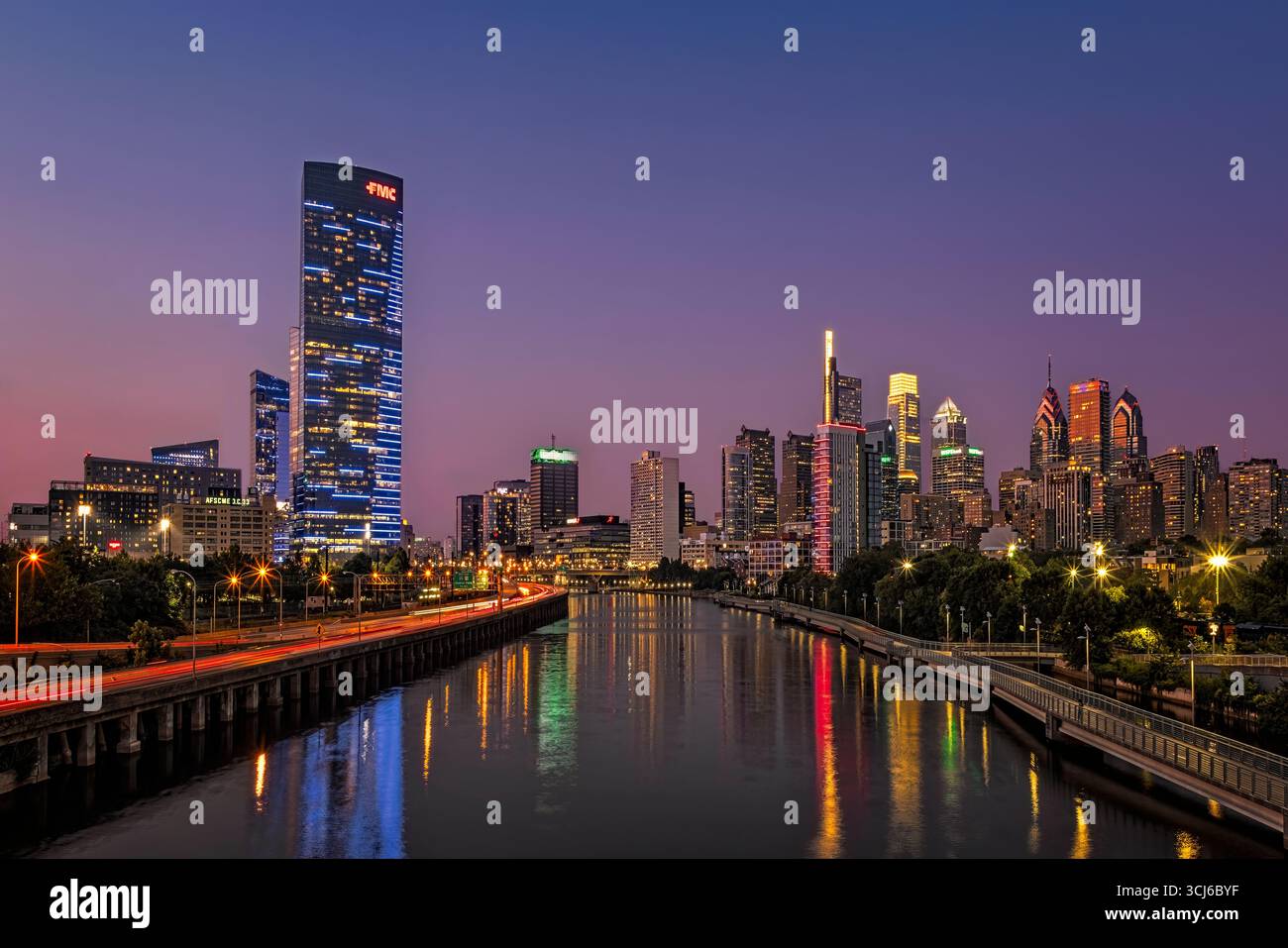 Die Skyline von Philadelphia leuchtet mit Lichtern der Stadt, während die Dämmerung über dem Schuylkill River einsetzt. Stockfoto