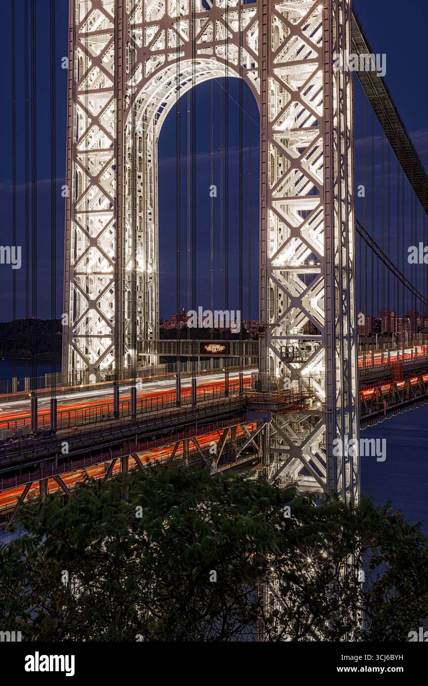 GW Bridge das beleuchtete Gateway V - die Türme der George Washington Bridge leuchten vor dem tiefen Blau des Nachthimmels. Stockfoto