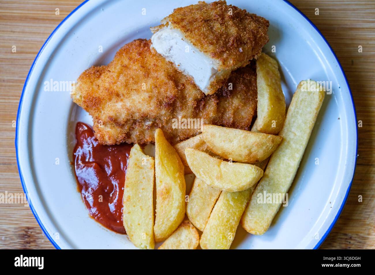 London UK, 05. September 2025, gebratene Hühnerfilet mit Chips und Tomatensauce Stockfoto