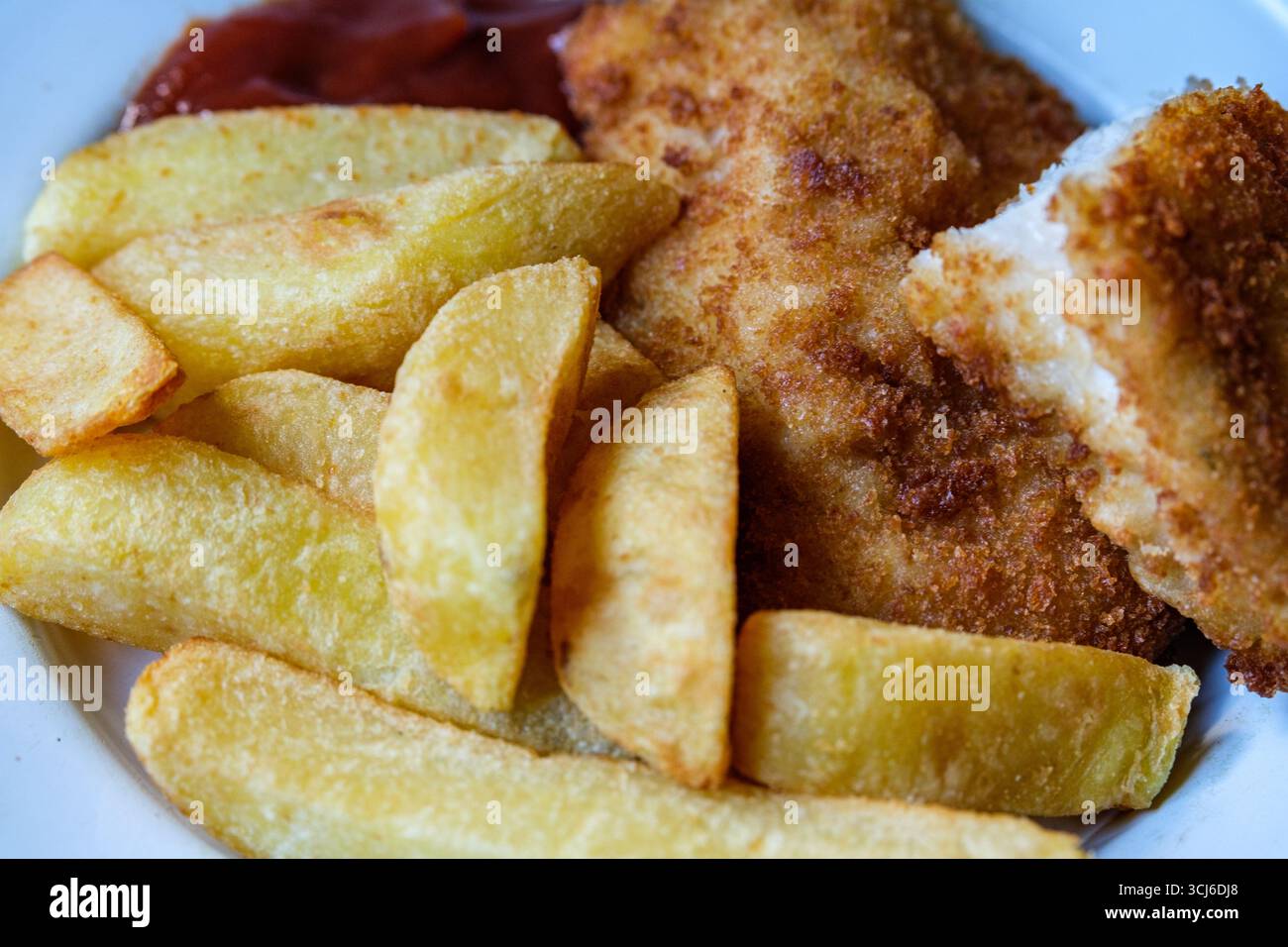 London UK, 05. September 2025, gebratene Hühnerfilet mit Chips und Tomatensauce Stockfoto