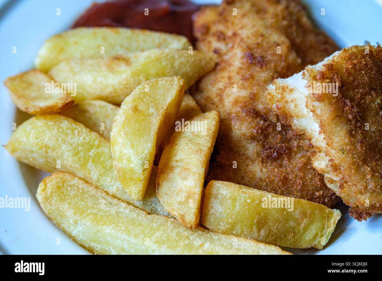 London UK, 05. September 2025, gebratene Hühnerfilet mit Chips und Tomatensauce Stockfoto