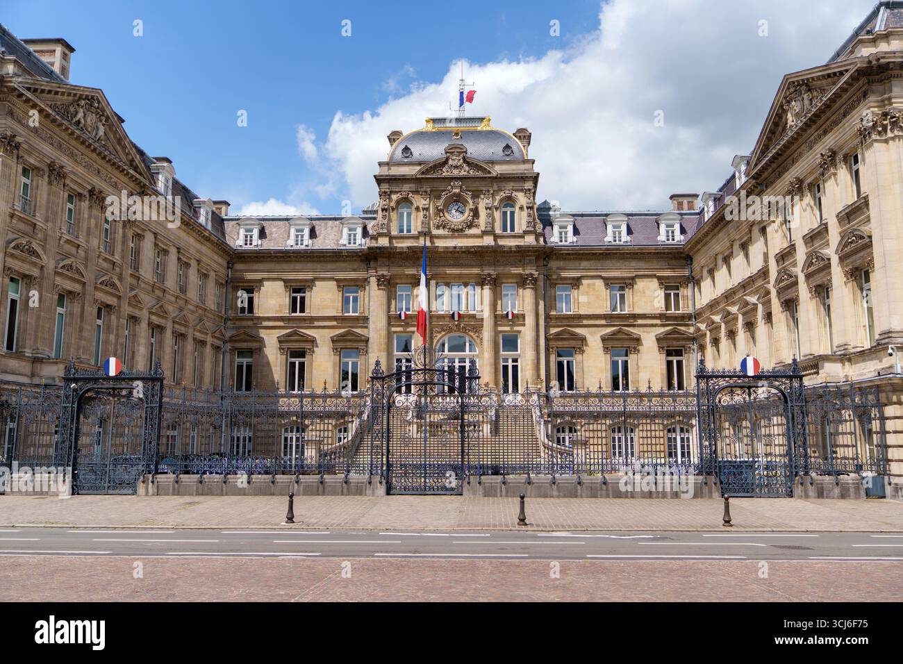 Weite Frontalansicht der Präfektur Lille mit Uhr und französischen Flaggen Stockfoto
