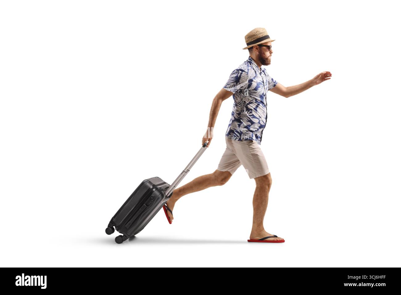 Profilaufnahme eines männlichen Touristen, der mit einem Koffer auf weißem Hintergrund läuft Stockfoto