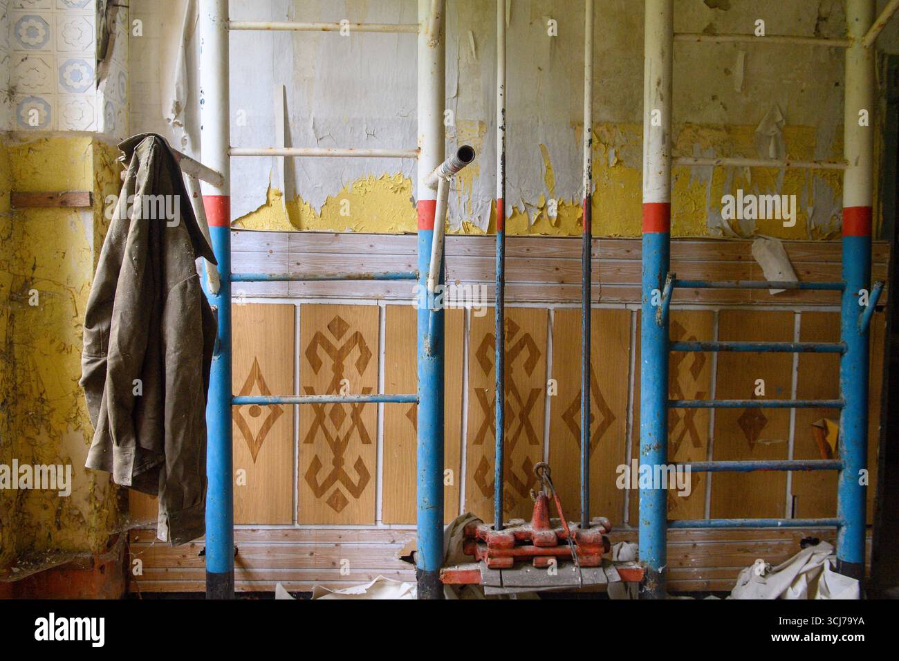 Gardelegen, Deutschland. September 2025. Eine alte Militärjacke hängt auf dem militärischen Trainingsbereich des GÜZ in einem verlassenen Gebäude, das bis zu ihrem Rückzug von der sowjetischen Armee genutzt wurde. Das GÜZ feiert 2025 sein 30-jähriges Bestehen. Quelle: Klaus-Dietmar Gabbert/dpa/Alamy Live News Stockfoto