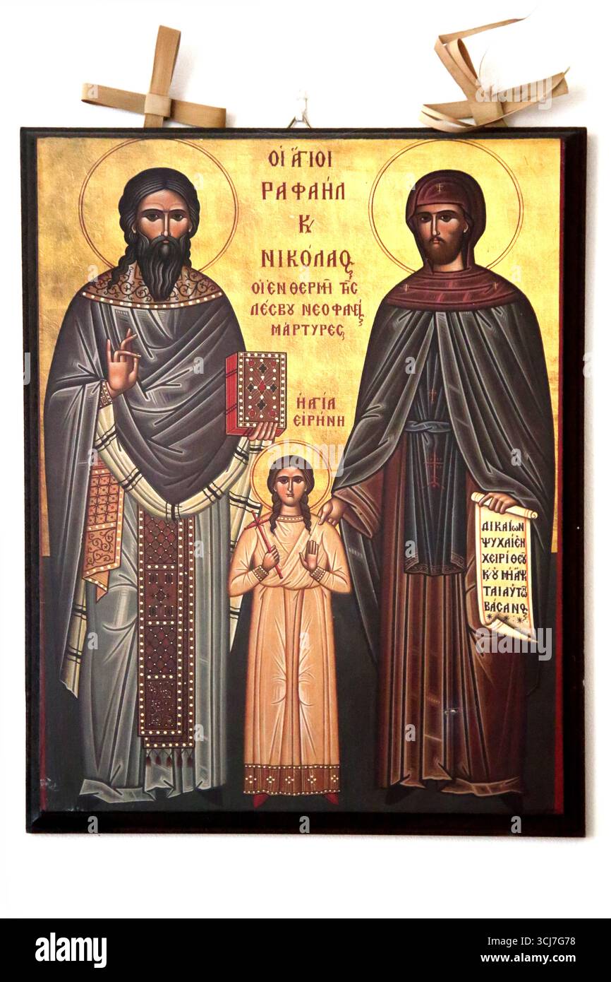 Griechische Ikone des Heiligen Raffael, des Heiligen Nikolaus und der Heiligen Irene New Märtyrer mit Palmblattkreuzen hinter dem Rahmen Stockfoto