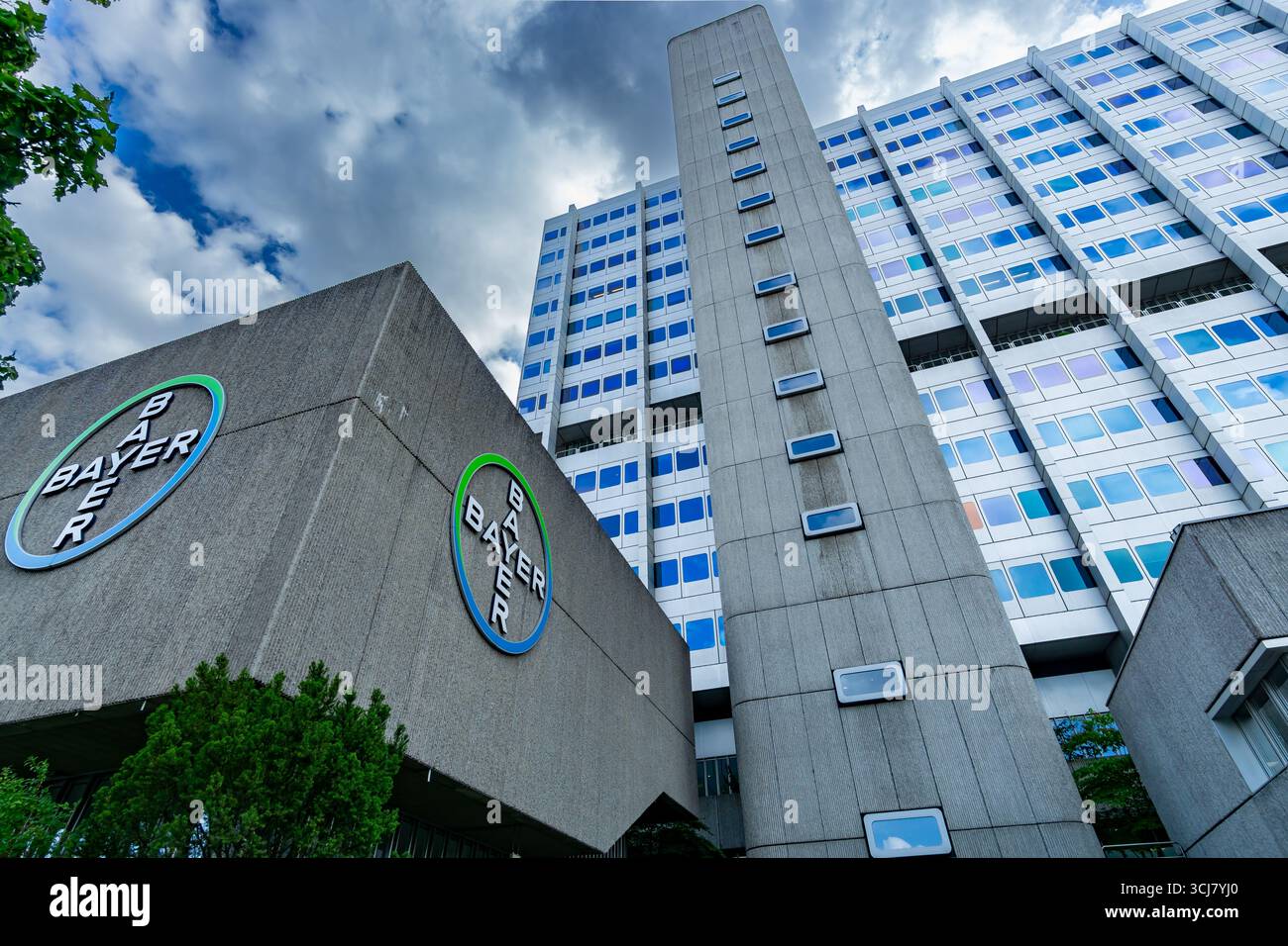 Detailansicht des Hauptsitzes der Bayer AG in Wedding mit Firmenemblem, Betonturm und modernen Bürofenstern. Stockfoto
