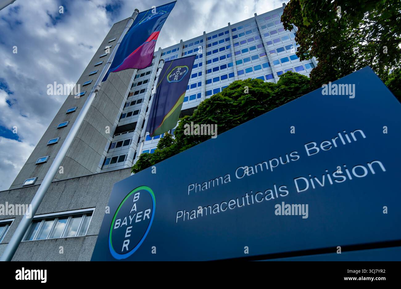 Nahaufnahme des Bayer AG Pharmaceuticals Campus in Berlin Wedding District mit Firmenflaggen und modernem Büroturm. Stockfoto