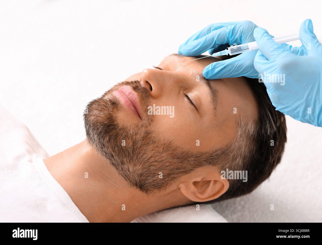 Kosmetologe Injektion Füllstoff zwischen Mann Brauen gegen Stirnrunzeln Stockfoto