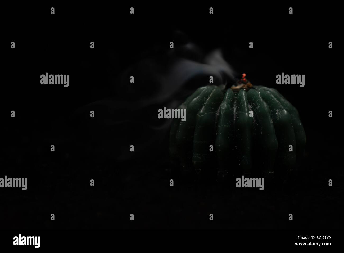 Brennende Kerze mit Flamme auf dunklem Hintergrund, Symbol der Hoffnung und Spiritualität Stockfoto