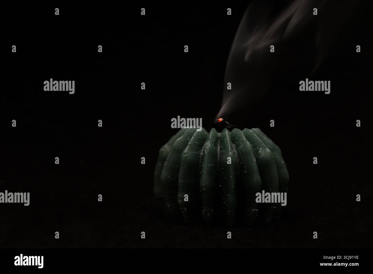 Brennende Kerze mit Flamme auf dunklem Hintergrund, Symbol der Hoffnung und Spiritualität Stockfoto