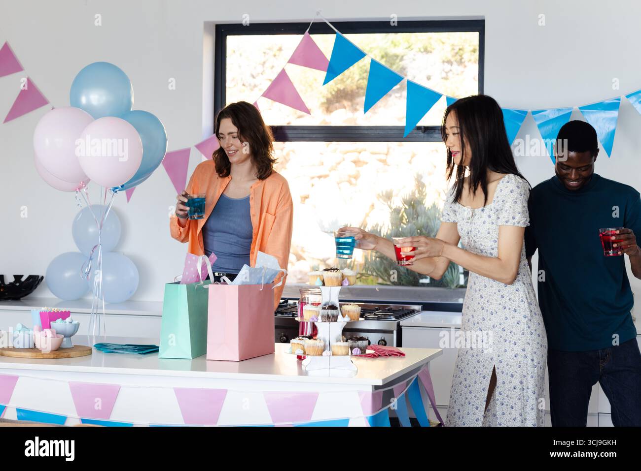 Freunde feiern zu Hause mit Getränken und Geschenken und genießen festliche Dekorationen Stockfoto