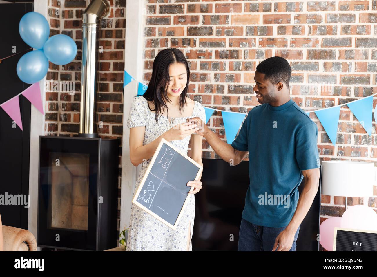 Paare, die das Geschlecht feiern, mit Tafel und Dekoration zu Hause Stockfoto