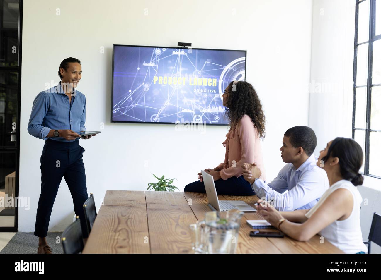 In modernen Büros diskutieren verschiedene Teams während des Meetings die Präsentation der Produkteinführung Stockfoto