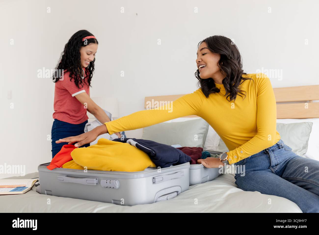 Mutter und Tochter packen Koffer ins Bett und bereiten sich auf den Familienausflug vor Stockfoto