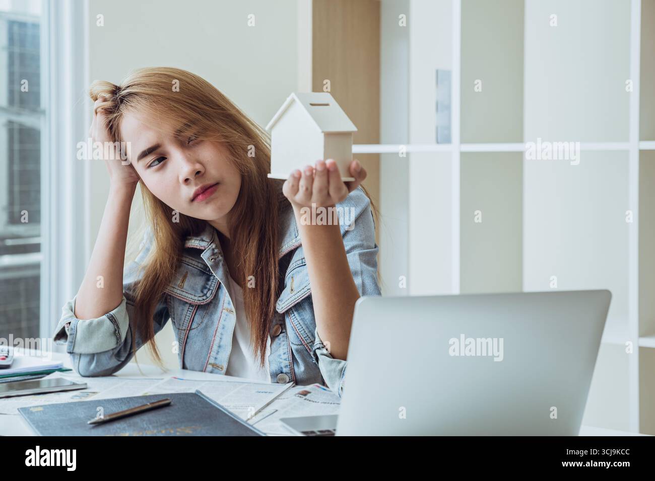Junge Menschen, die sich auf das Heimatmodell schauen, fühlen sich besorgt Sorgen Stress beim Denken über Hausrechnungen und Ratenzahlungen Kosten Kreditschulden Stockfoto