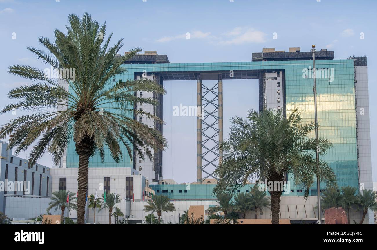 Ein großer Blick auf den Gate Tower des King Abdullah Financial District in Riad, Saudi-Arabien, mit Palmen im Vordergrund, an einem hellen Tag. Stockfoto