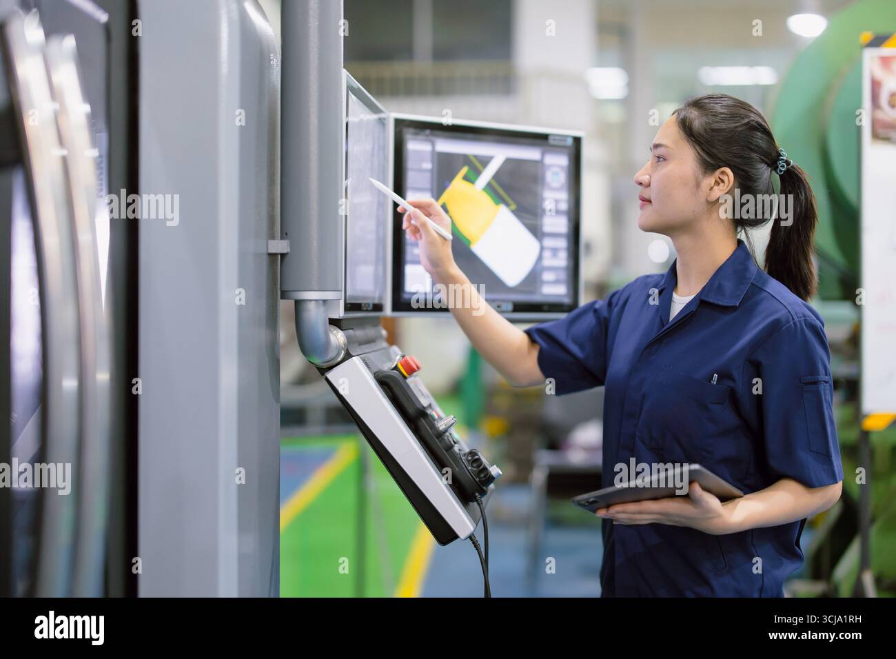 Junge Techniker Ingenieurarbeiterinnen arbeiten mit CNC-Drehmaschine in modernen Stahlindustriefabriken Stockfoto
