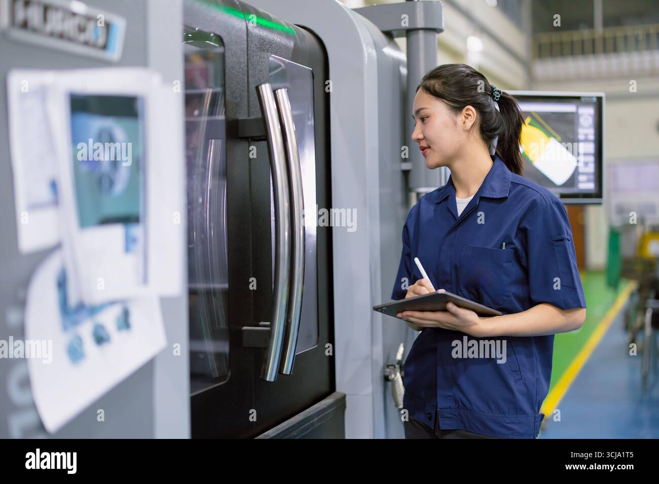 Junge Techniker Ingenieurarbeiterinnen arbeiten mit CNC-Drehmaschine in modernen Stahlindustriefabriken Stockfoto Junge Techniker Ingenieurarbeiterinnen arbeiten mit CNC-Drehmaschine in modernen Stahlindustriefabriken Stockfoto