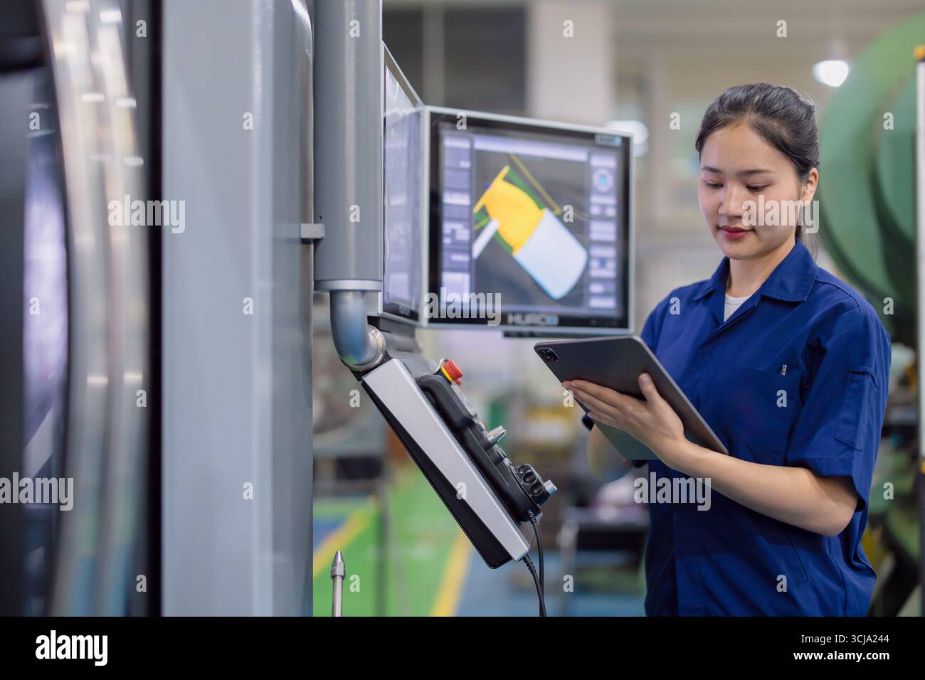 Junge Techniker Ingenieurarbeiterinnen arbeiten mit CNC-Drehmaschine in modernen Stahlindustriefabriken Stockfoto