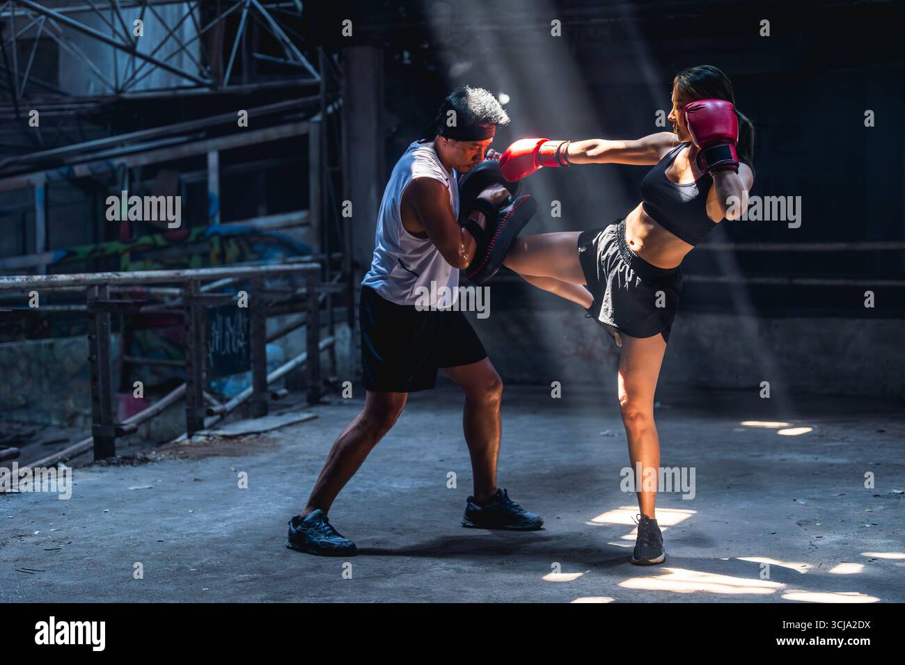 Thai Boxen, Muay thai, Frauen Kämpfer Training Kick Boxen mit Trainer in Ruinen Gebäude, asiatische Kampfkunst Kampfszene Stockfoto