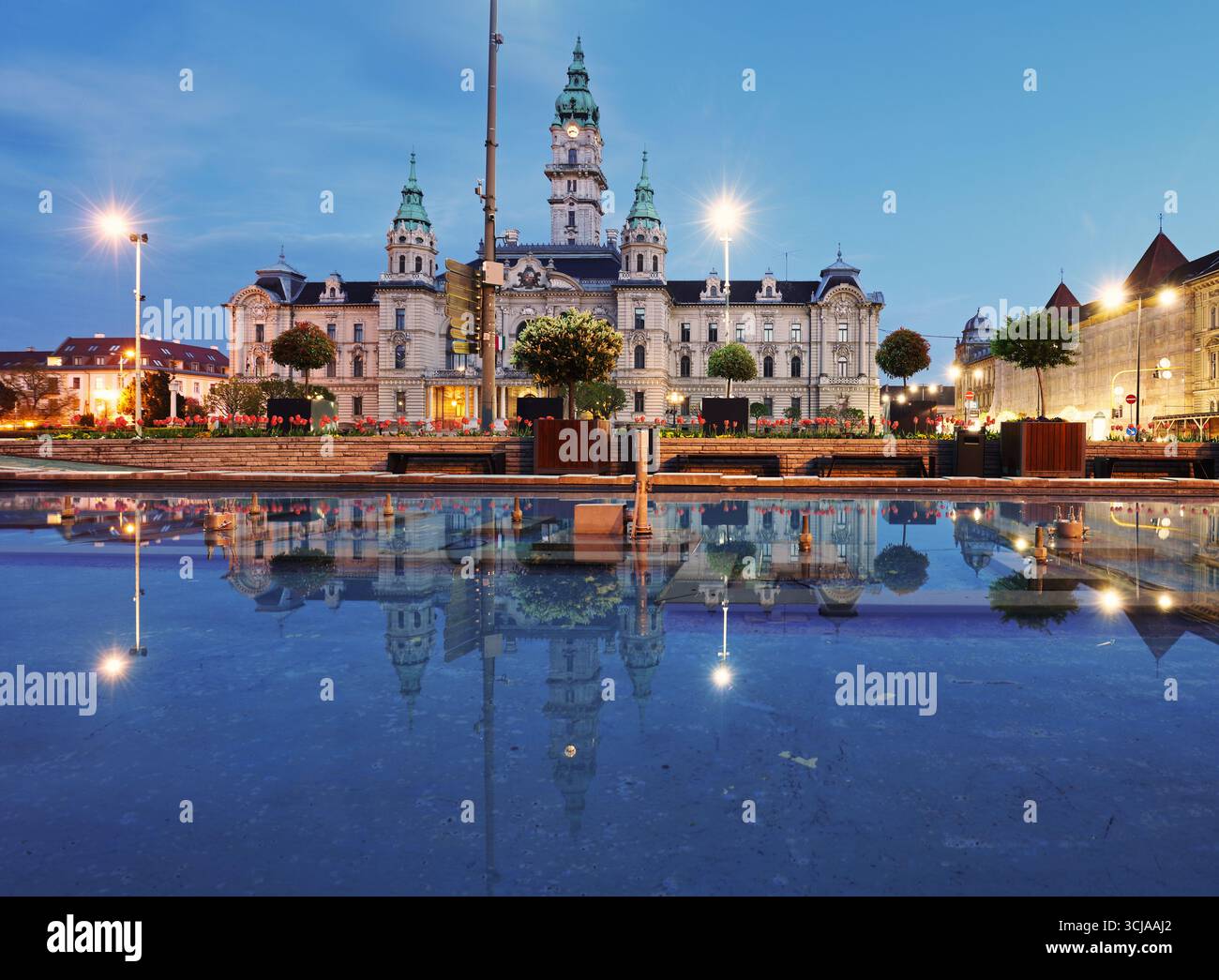 Gyor Rathaus bei Nacht mit Reflexion im Wasser, Ungarn Stockfoto