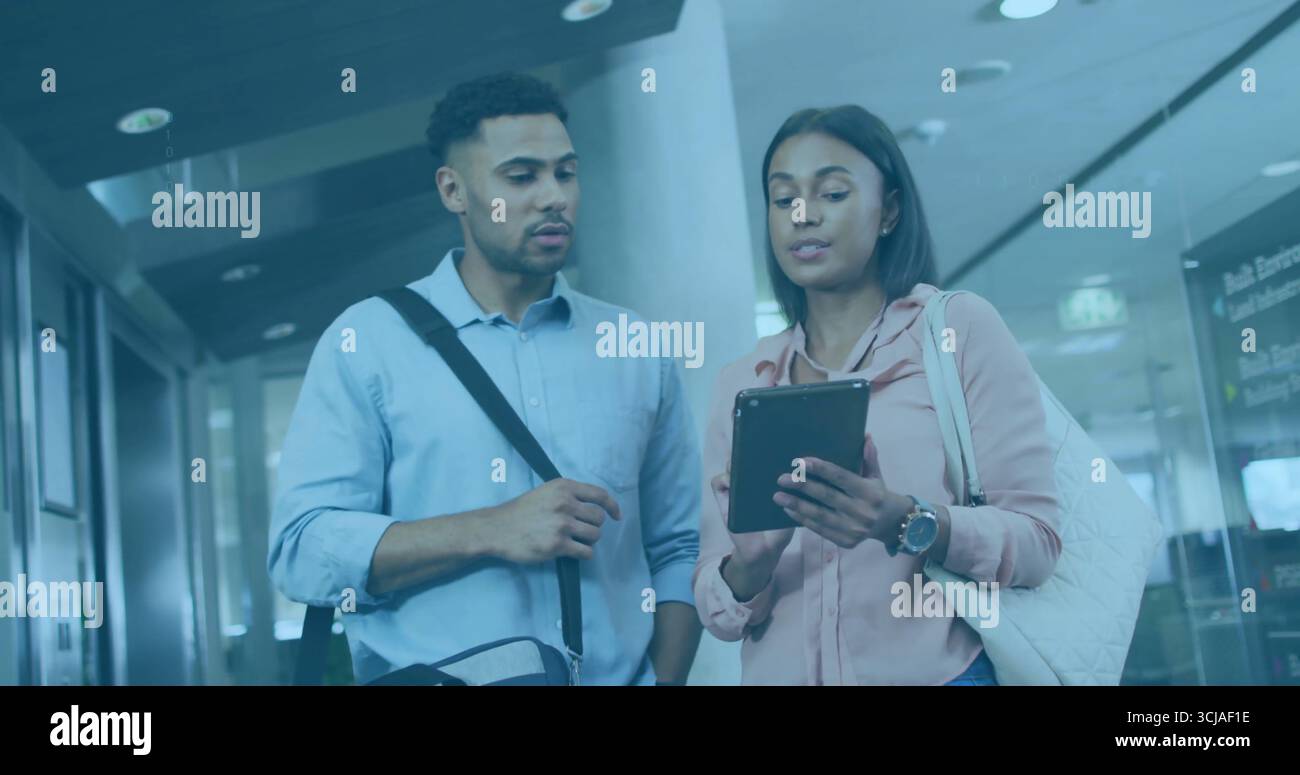 Paare bewerten ein Tablet in der Abflughalle mit Kuriertasche, Tragetasche und Digital Signage Board Stockfoto