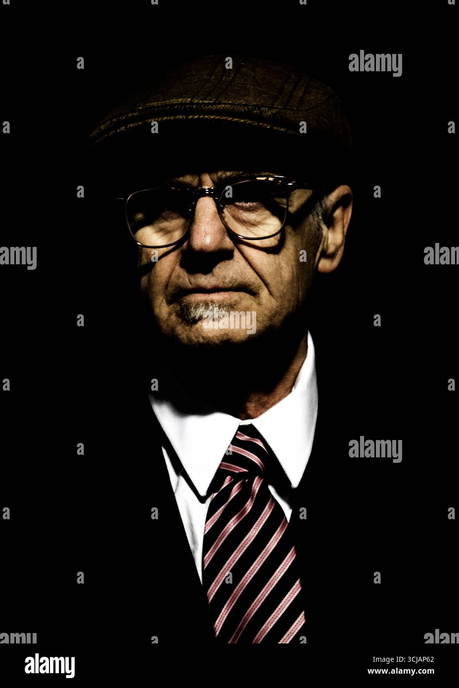 Ein Porträt eines Mannes mit Hut, Brille, Anzug und Krawatte. Stockfoto