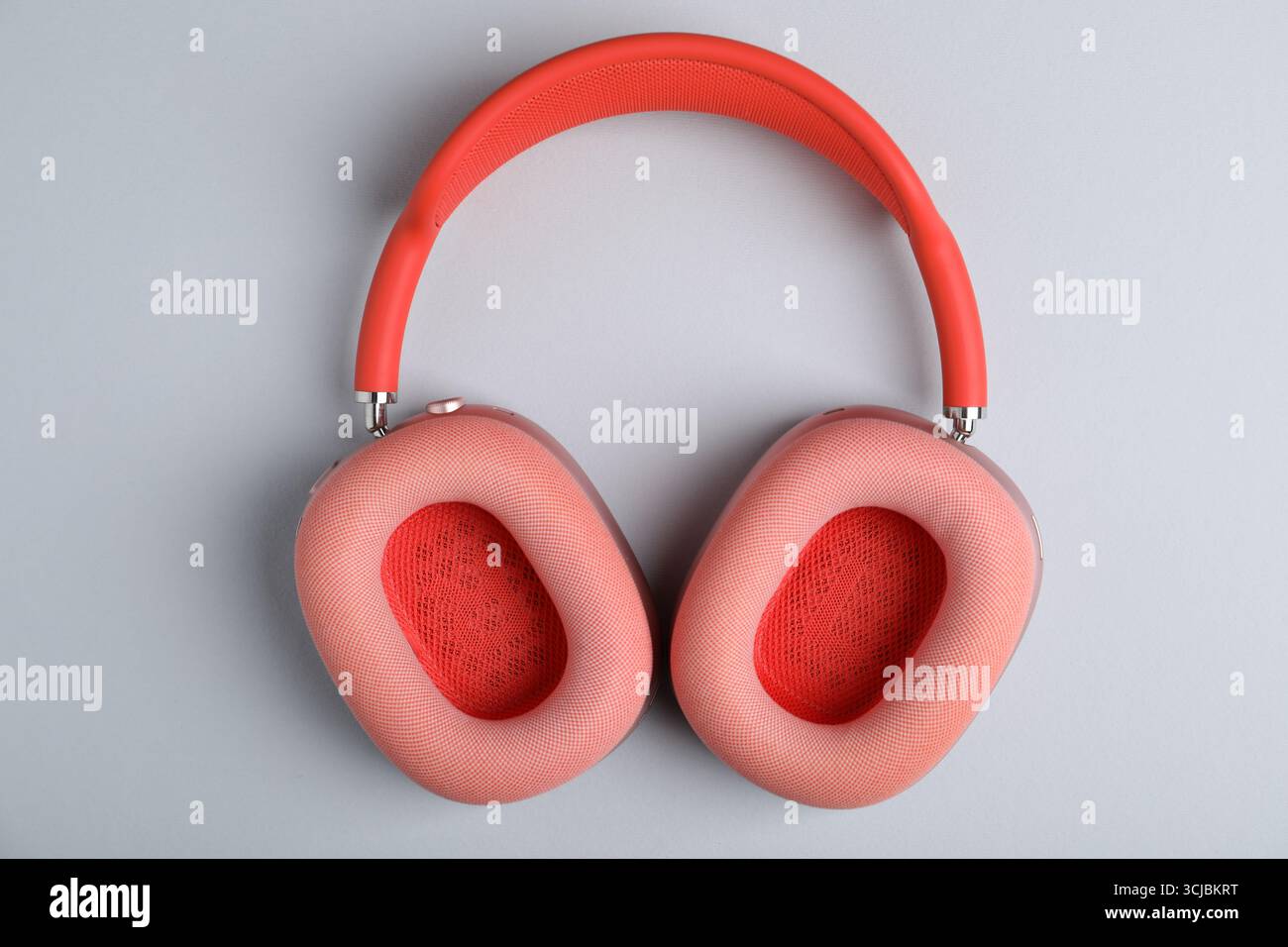 Ein Paar stilvoller rosafarbener Kopfhörer auf hellgrauem Hintergrund, Draufsicht Stockfoto