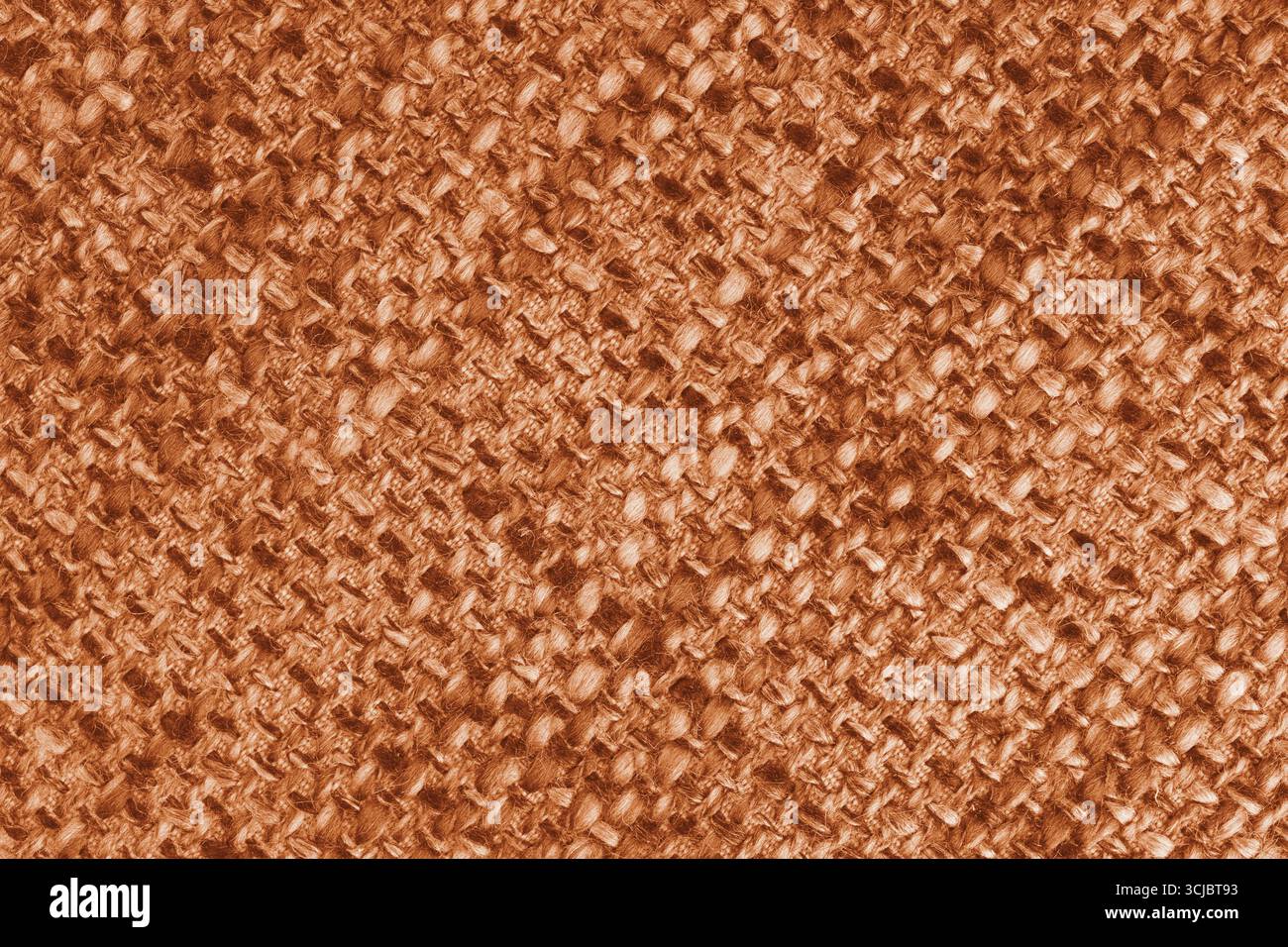 Makro, Nahaufnahme aus orangem gewebtem Sackleinen-Stoff, Stoffstruktur mit dicken Fäden und rauem Textilmuster. Grobe Textiloberfläche mit sichtbaren Fasern. Stockfoto