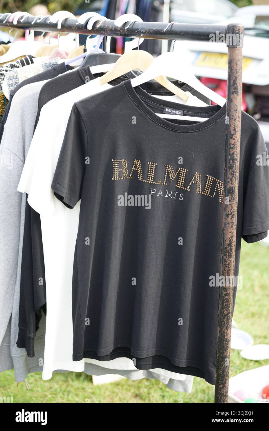 Schwarzes T-Shirt mit Nieten-Logo auf einem Kleiderständer im Freien. Faygate, Horsham, England Stockfoto