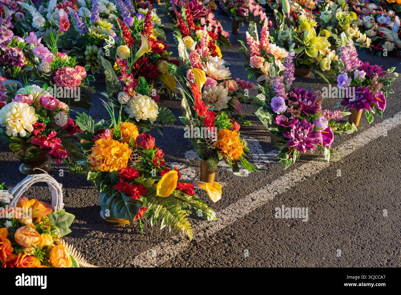 Farbenfrohe künstliche Blumenarrangements für die Friedhofsdekoration Stockfoto