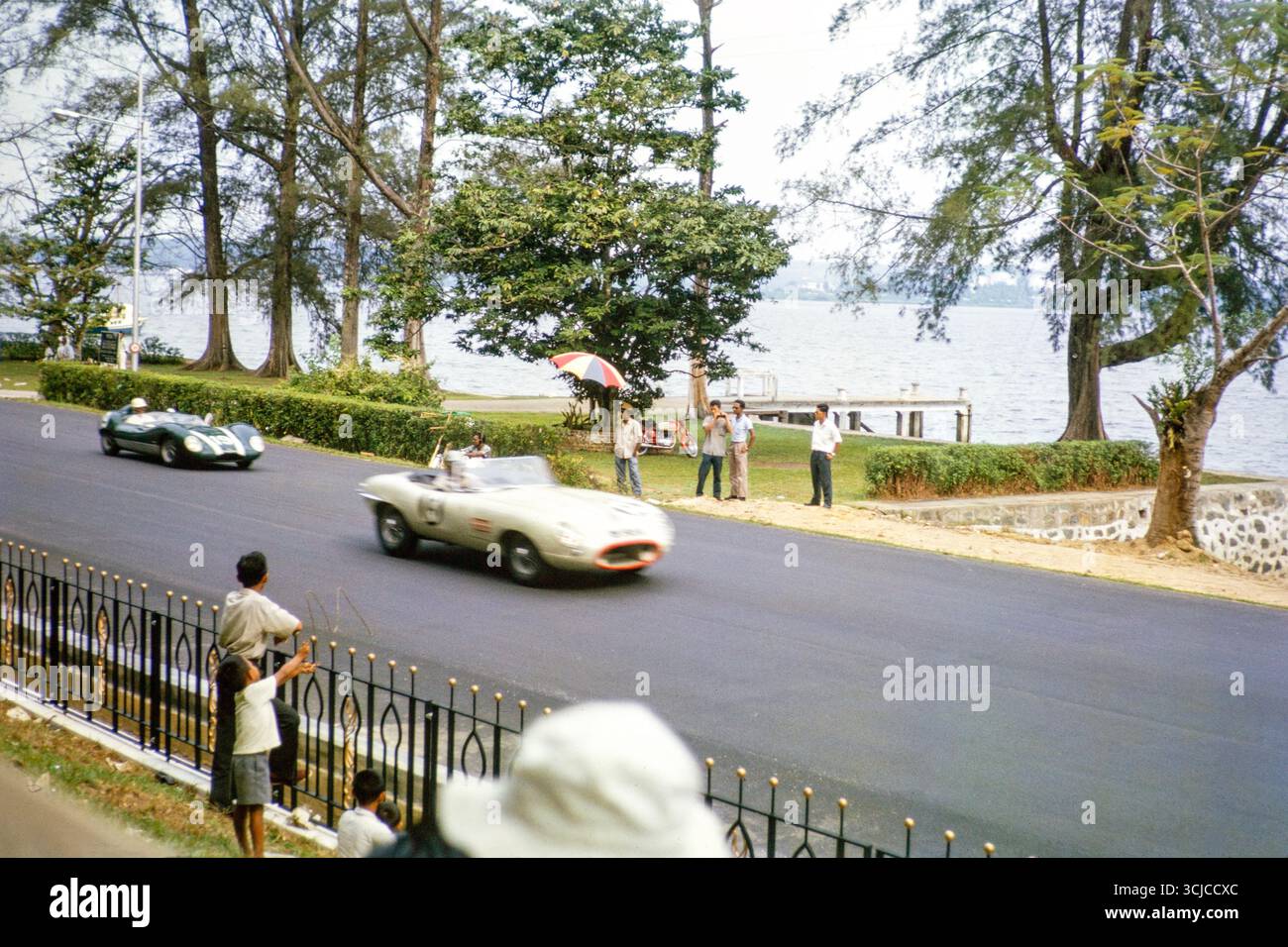 Jaguar E-Type Auto, das vermutlich von Freddie Johns und Lola Mk1 gefahren wird, die am 2. September 1963 beim Formule Libre Johore Grand Prix in Johor Bahru, Malaysia, teilnahmen Stockfoto