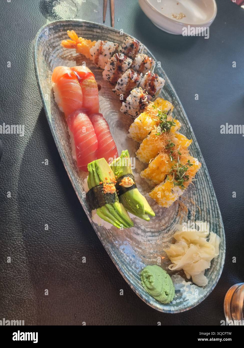 Verschiedene japanische Sushi-Platte mit Nigiri, Maki-Brötchen und Sashimi. - Smartphone-aufgenommenes Stockfoto