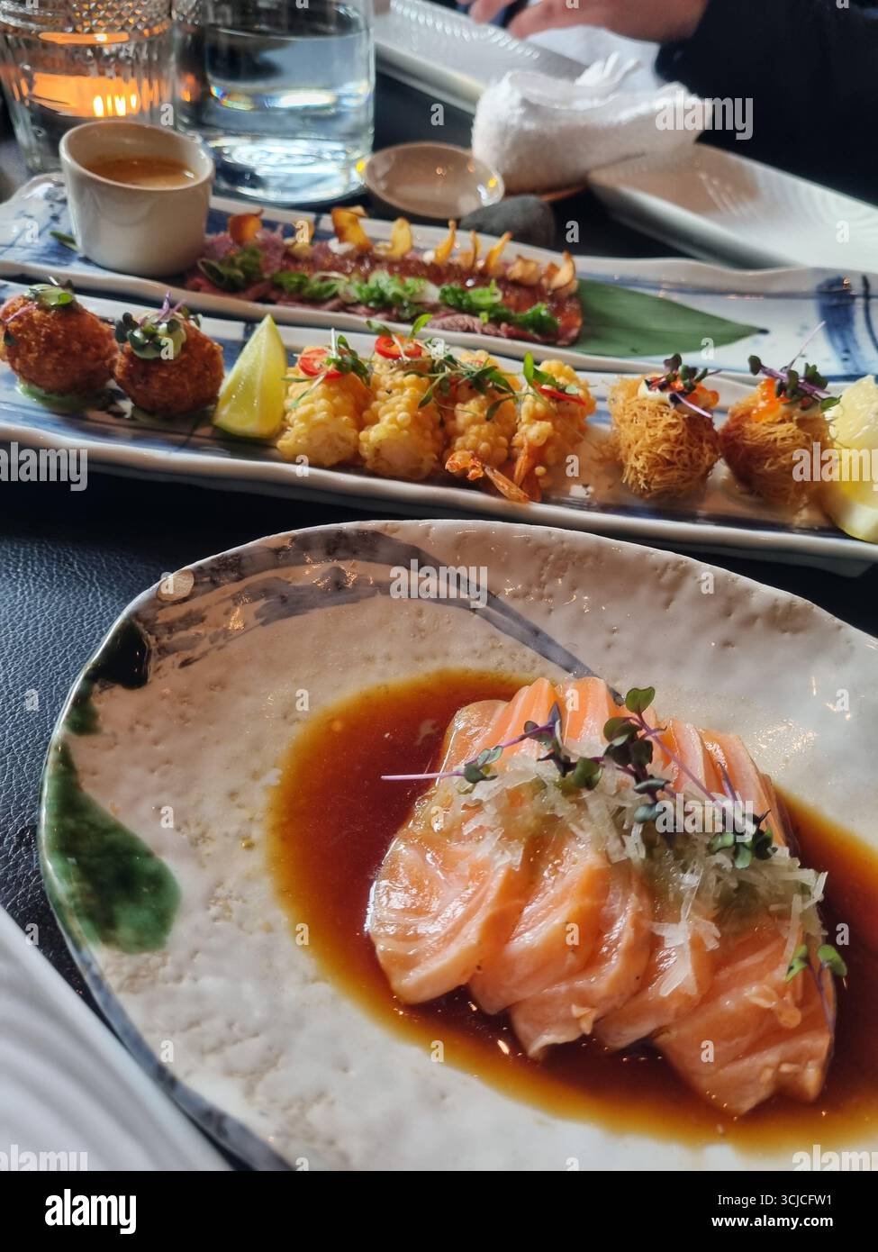 Sushi-Platte mit Lachs und Thunfisch - Smartphone-aufgenommenes Stockfoto