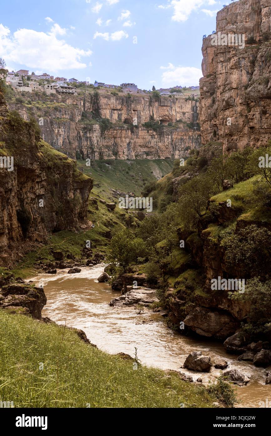 Der Rawanduz Canyon in der irakischen Region Kurdistan bietet steile Klippen und einen Fluss, der sich durch ein üppiges, grünes Tal schlängelt. Diese unberührte Landschaft ist ein po Stockfoto