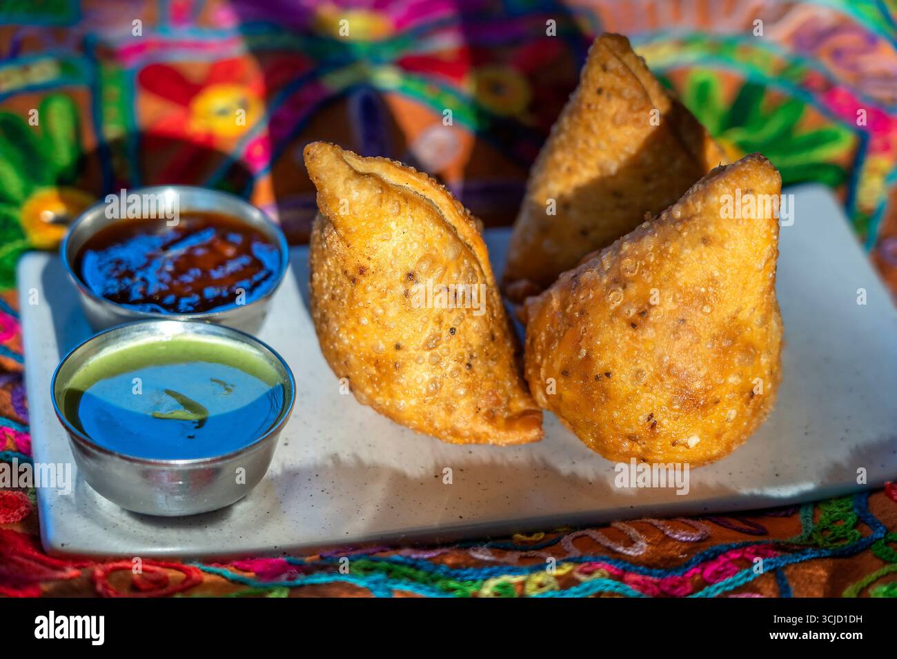 Vegetarische Samosas mit Saucen, Nahaufnahme. Gebratene Kartoffelsamosa auf Teller. Indische Küche Stockfoto