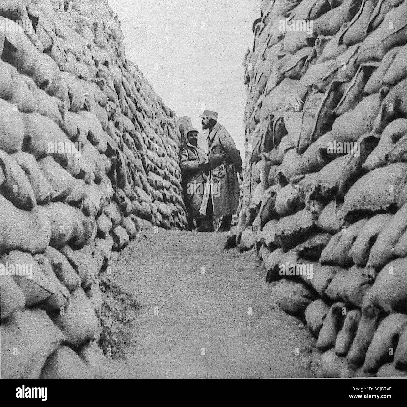 Foto aus Le Miroir, 1915, mit einem Graben, der vollständig mit Sandsäcken in Nordfrankreich gebaut wurde. Die dicken, regelmäßigen Mauern zeigen eine organisierte Verteidigungskonstruktion, die typisch für die Westfront ist. Soldaten posieren innerhalb des befestigten Korridors und spiegeln die Ausdauer und Struktur des Grabenlebens während des Ersten Weltkriegs wider. Stockfoto