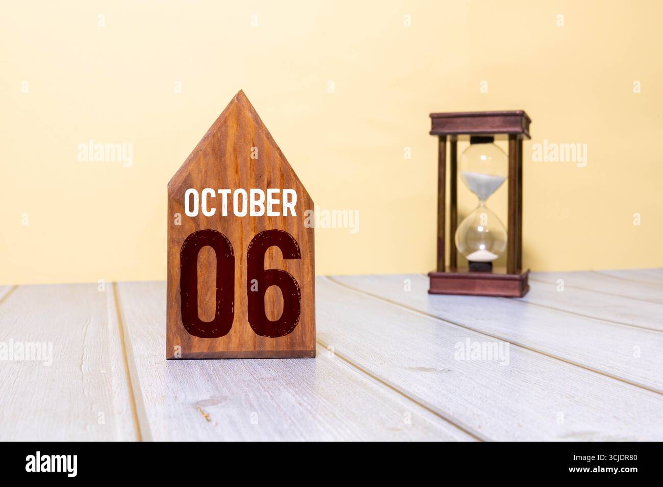 Holzkalender mit Datum 6. Oktober. Monatskalender für Planung und Management-Konzept mit Wecker auf hölzernem Hintergrund Stockfoto