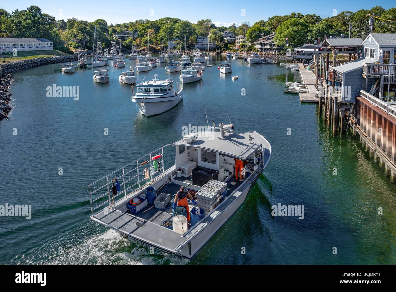 Hummerboot zurück zum Dock: Ein kommerzielles Fischerboot mit Hummer-Boxen fährt in einen kleinen Hafen in der Nähe von Ogunquit, Maine. Stockfoto