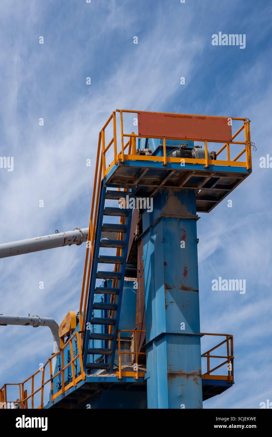 Hoher Industriestruktor aus blauem Metall mit orangefarbenen Treppen und Plattform in realistischem Stil, vor einem teilweise bewölkten blauen Himmel Stockfoto
