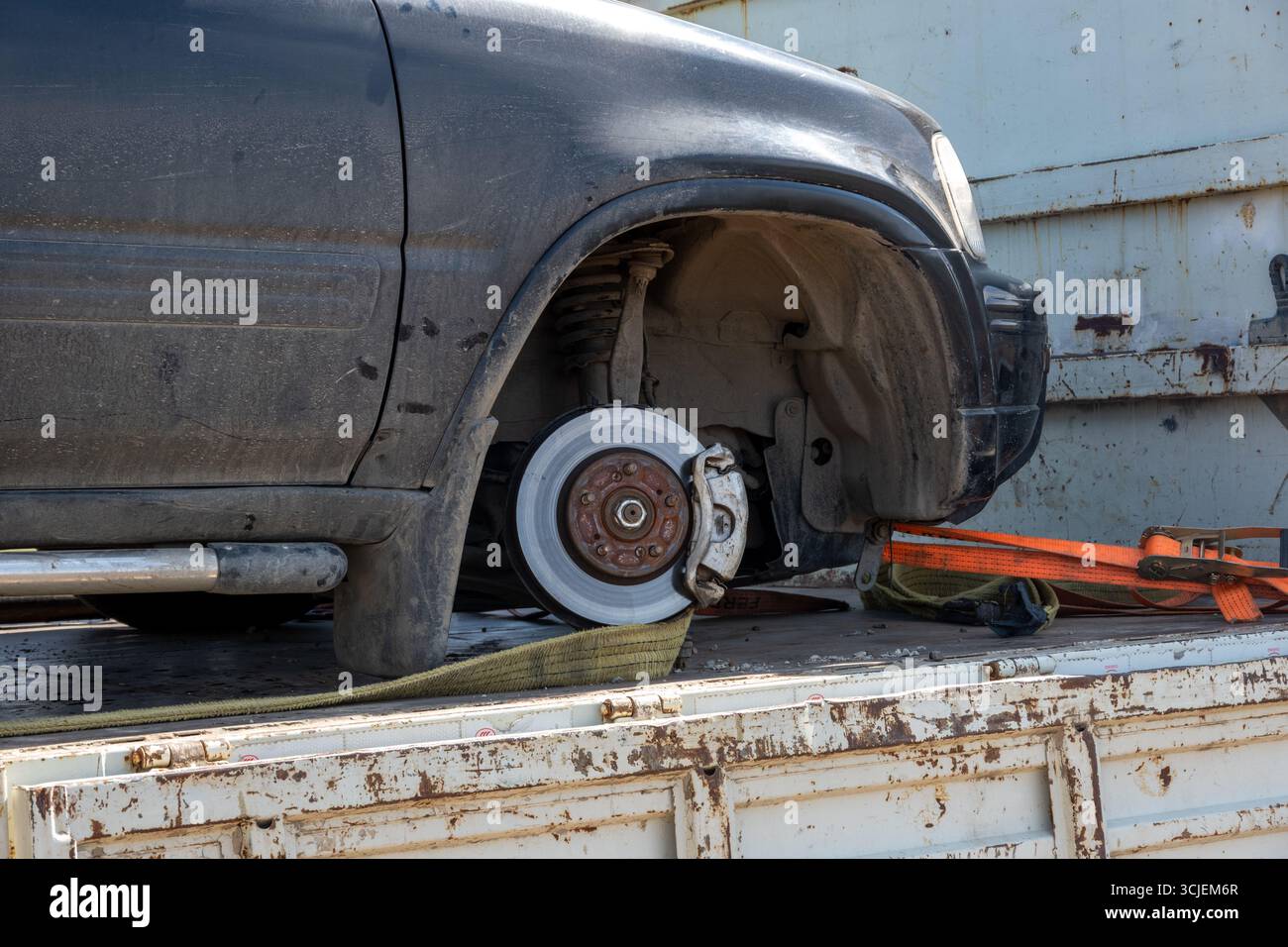 Nahaufnahme eines beschädigten Autos ohne Vorderrad auf einem rostigen Abschleppwagen, realistischer Fotostil, städtischer Außenbereich, Konzept der Pannenhilfe Stockfoto