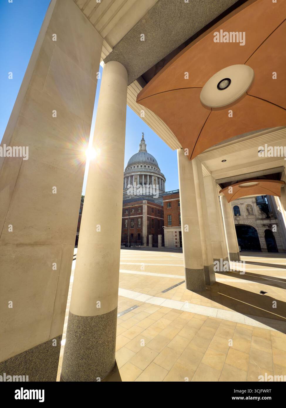 Sonnenschein zwischen Säulen auf dem Paternoster-Platz mit St. Paul's Cathedral, eingerahmt von Säulen. Stockfoto